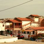 Casas tradicionais de uma comunidade costeira brasileira sob céu claro.