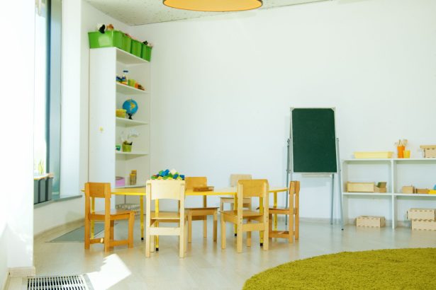 Sala de educação infantil colorida, com mesas, cadeiras e materiais educativos organizados.