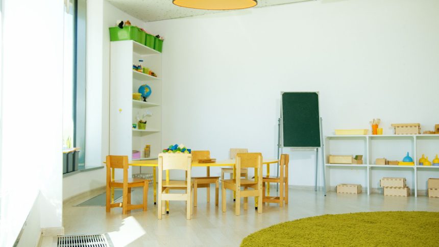Sala de educação infantil colorida, com mesas, cadeiras e materiais educativos organizados.