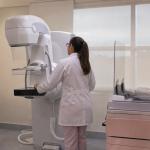 Profissional de saúde opera equipamento de mamografia digital em uma sala de exames de unidade pública