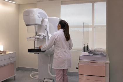 Profissional de saúde opera equipamento de mamografia digital em uma sala de exames de unidade pública