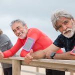Grupo de pessoas idosas realizando exercícios físicos ao ar livre.